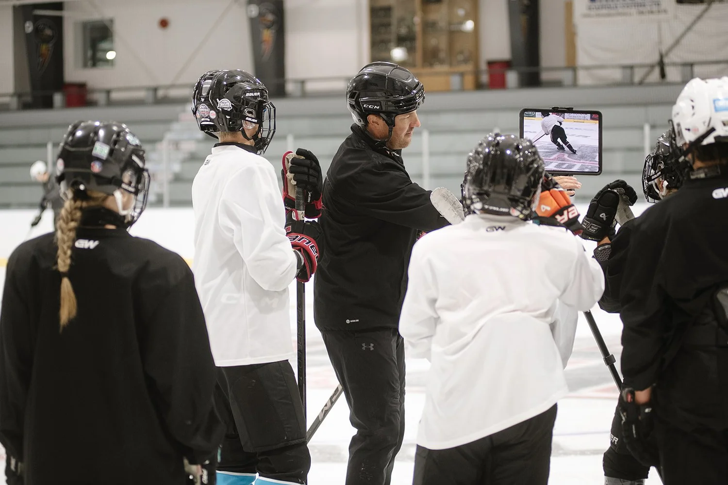 Bryce coaching a group using video on the ice