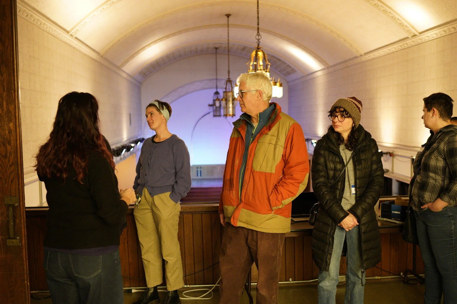 A group gathers beneath the arched ceiling during a tour of the space.