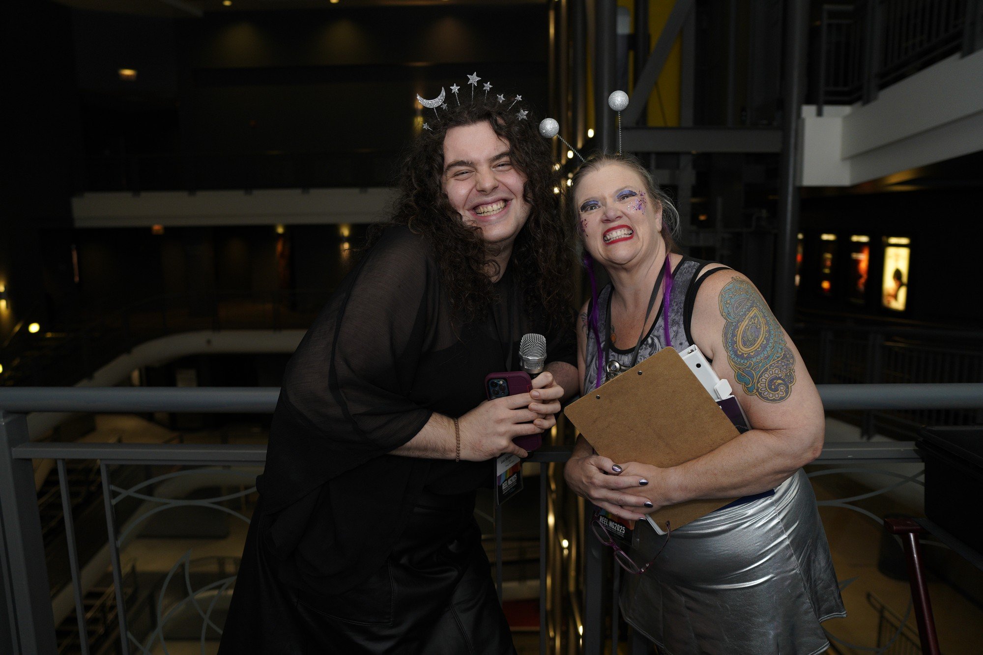 Two smiling attendees lean together for a photograph at the festival gathering.