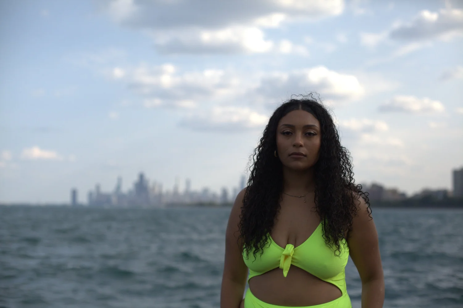 A neon swimsuit stands out against the water and hazy skyline.