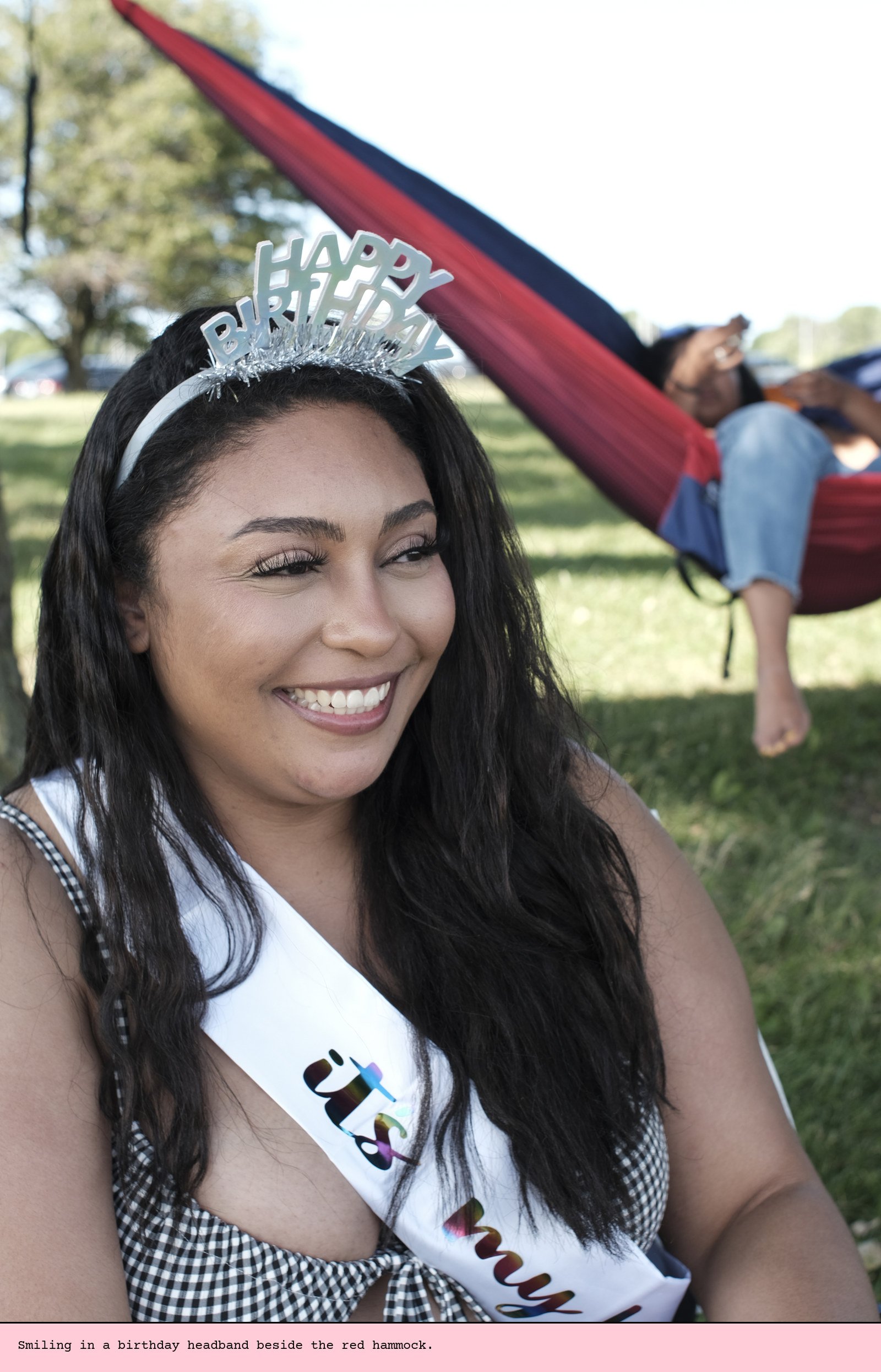 Smiling in a birthday headband beside the red hammock.