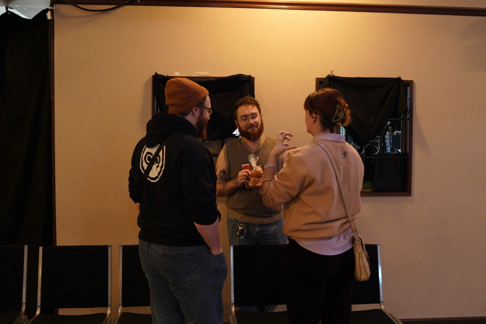 Three guests talk together during the open house.