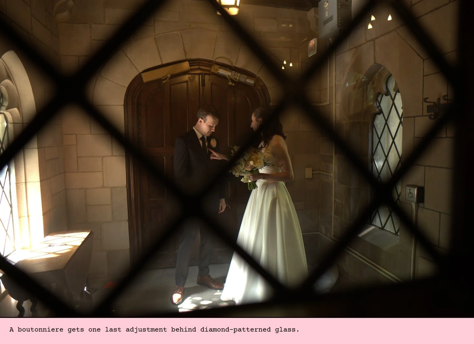 A boutonniere gets one last adjustment behind diamond-patterned glass.