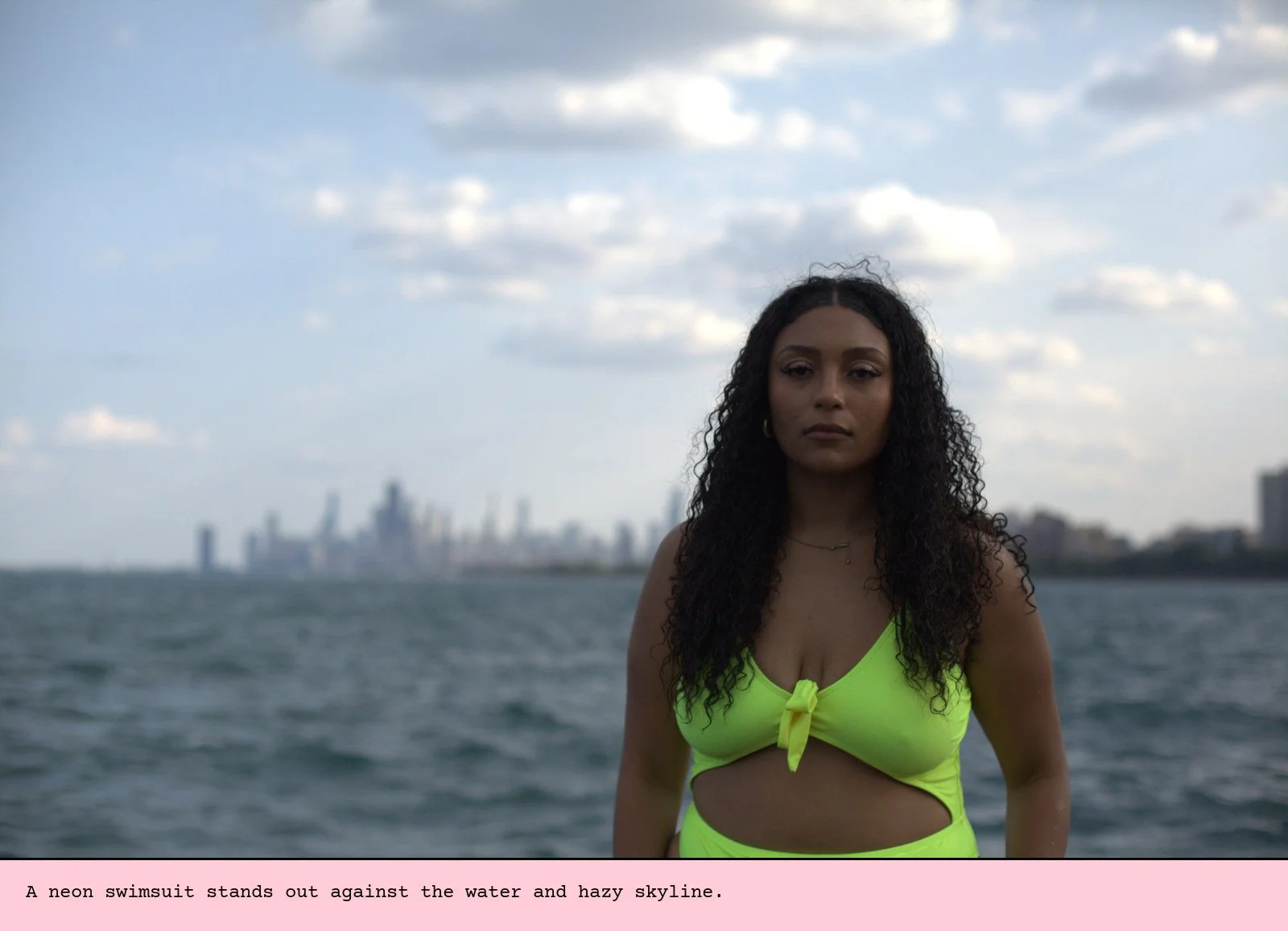 A neon swimsuit stands out against the water and hazy skyline.