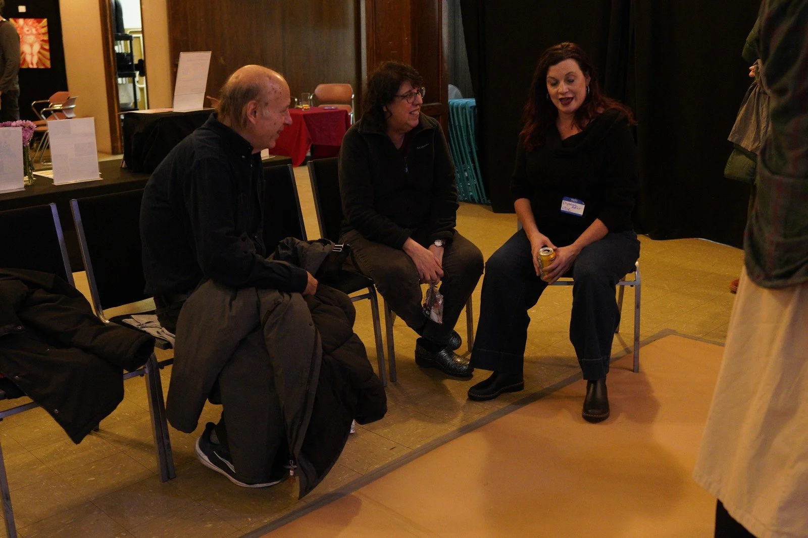 Three seated guests share a laugh during the event.