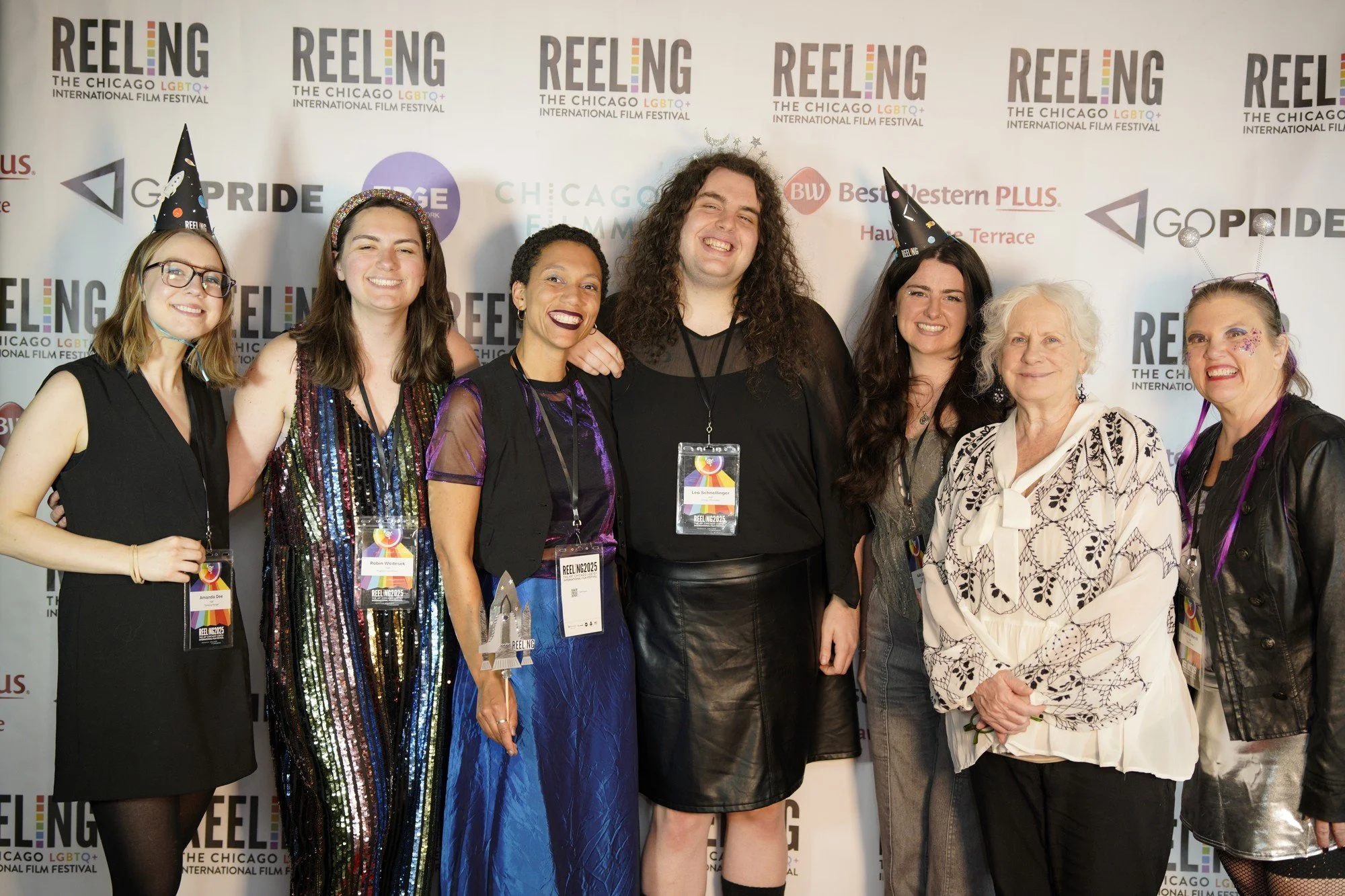 A group of festival attendees smile together in front of the Reeling backdrop.