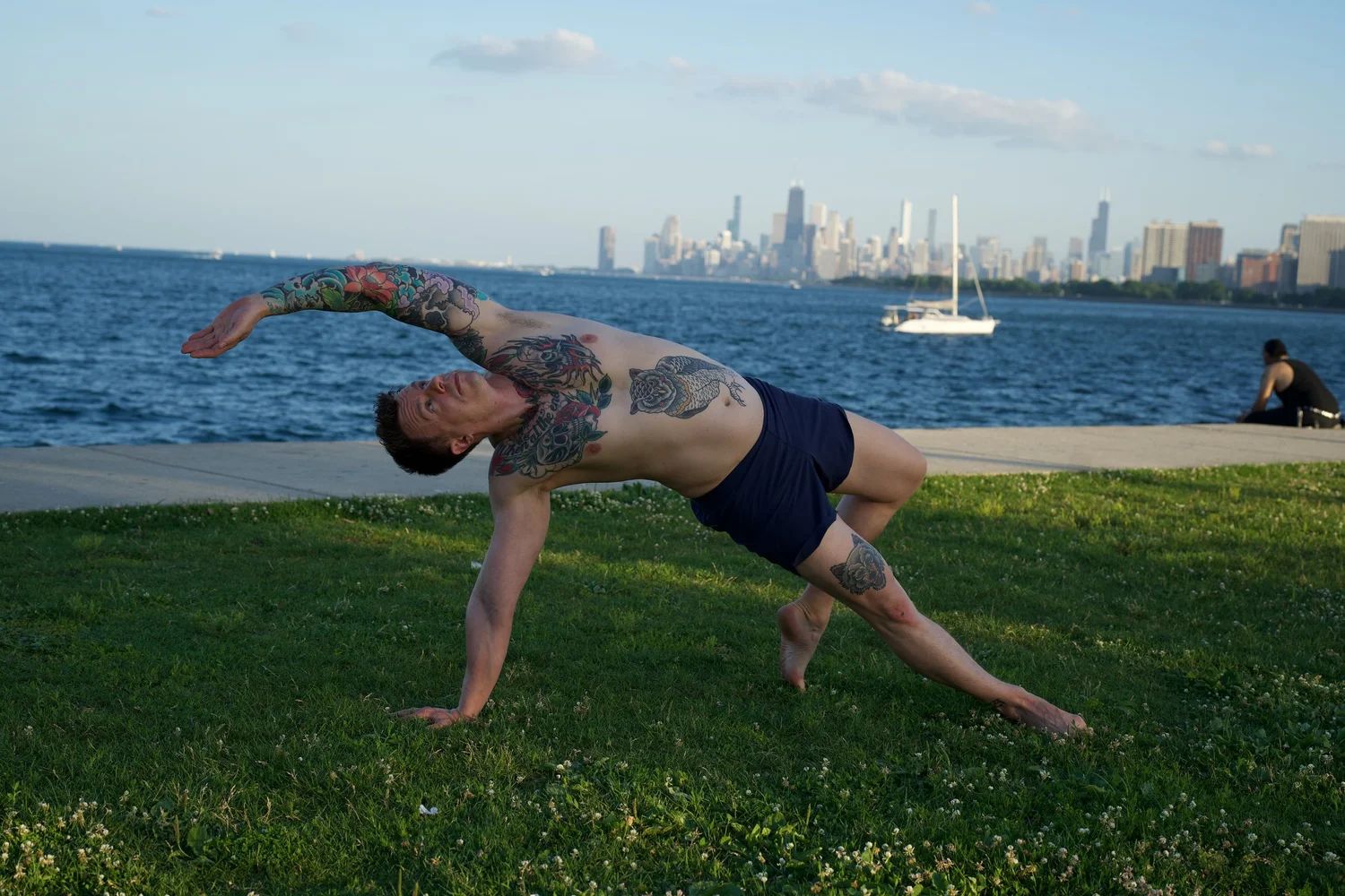 One arm arcs overhead during a lakeside balance.