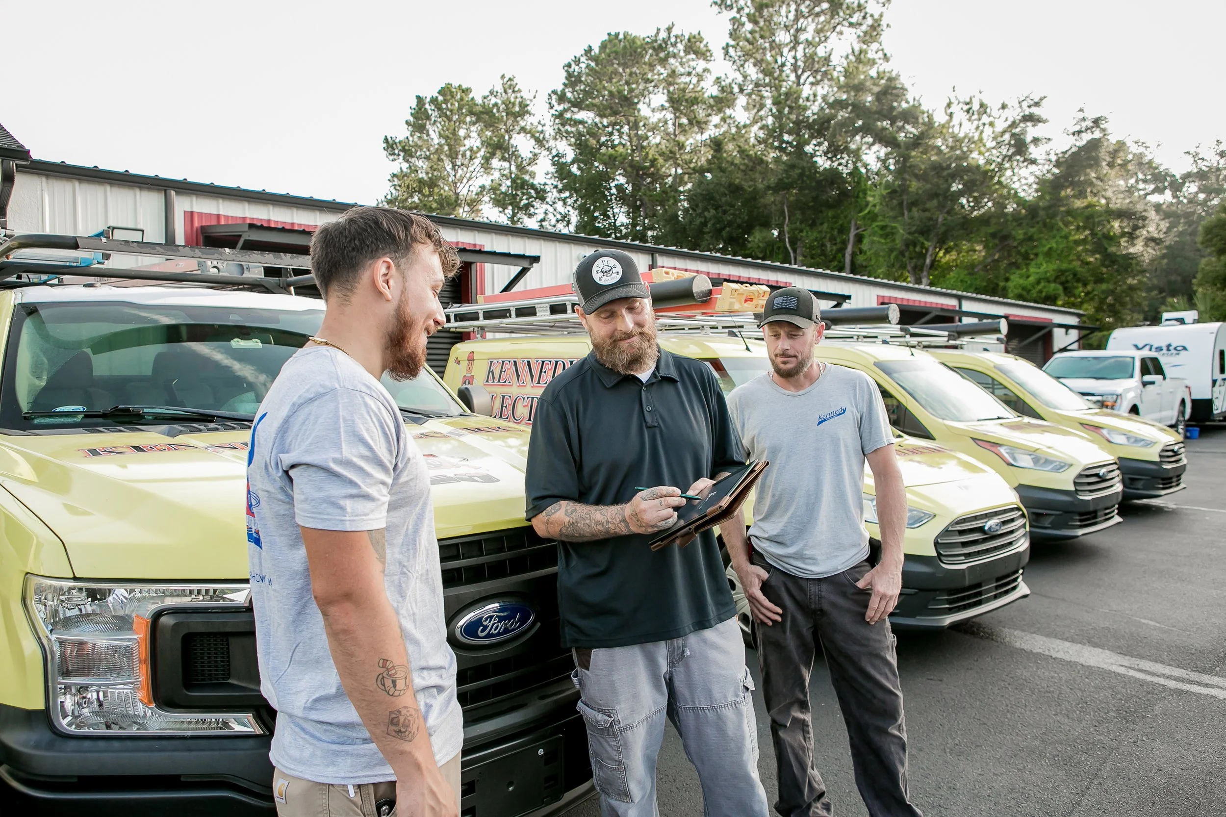Two men reviewing a tablet by vans