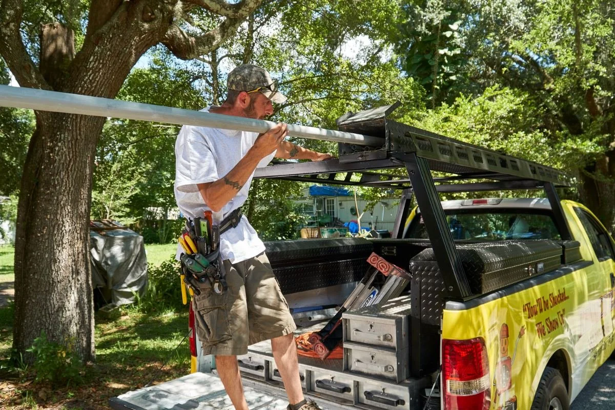 Kennedy Electric electrician with conduit at the work truck