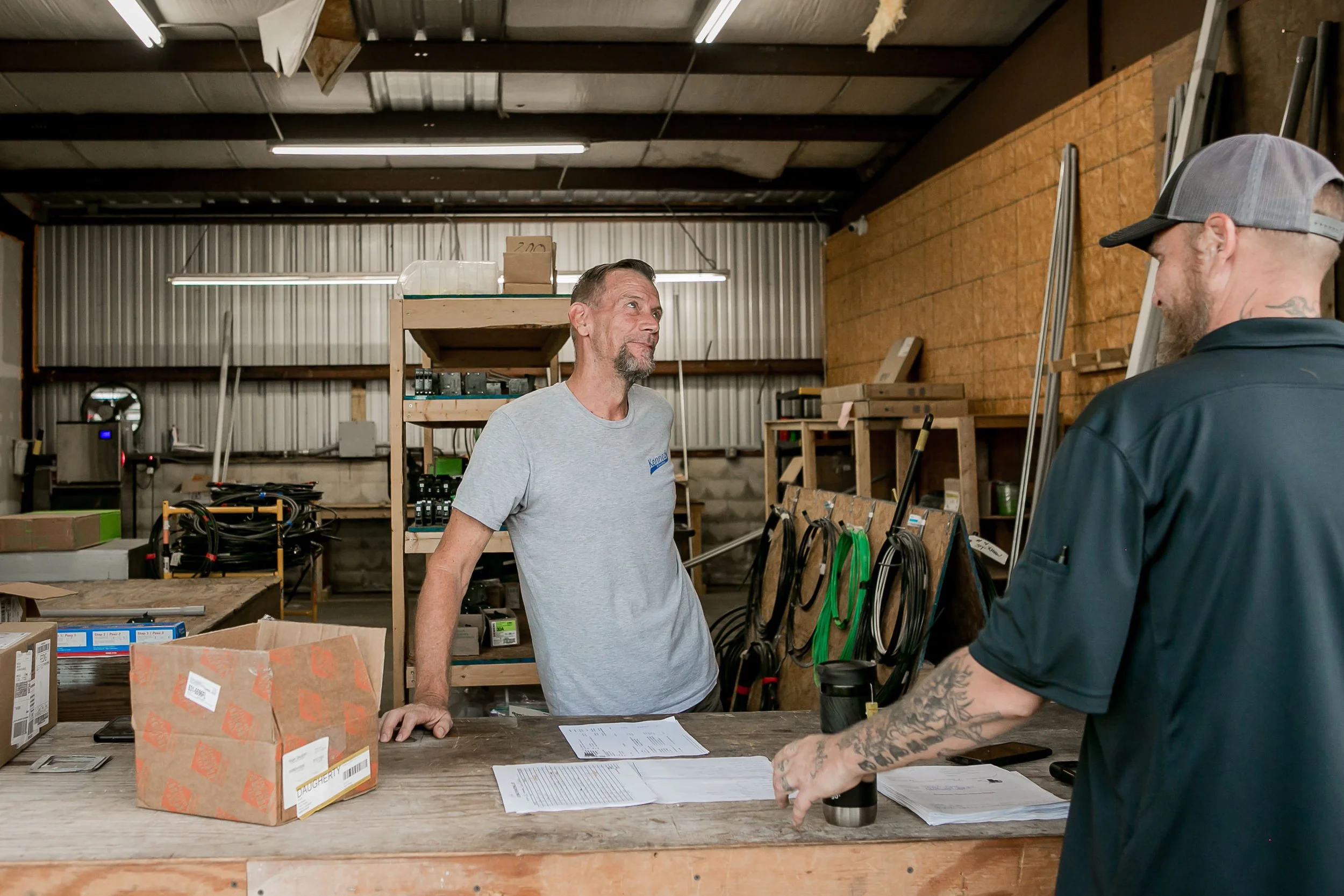 Two men at a warehouse workbench