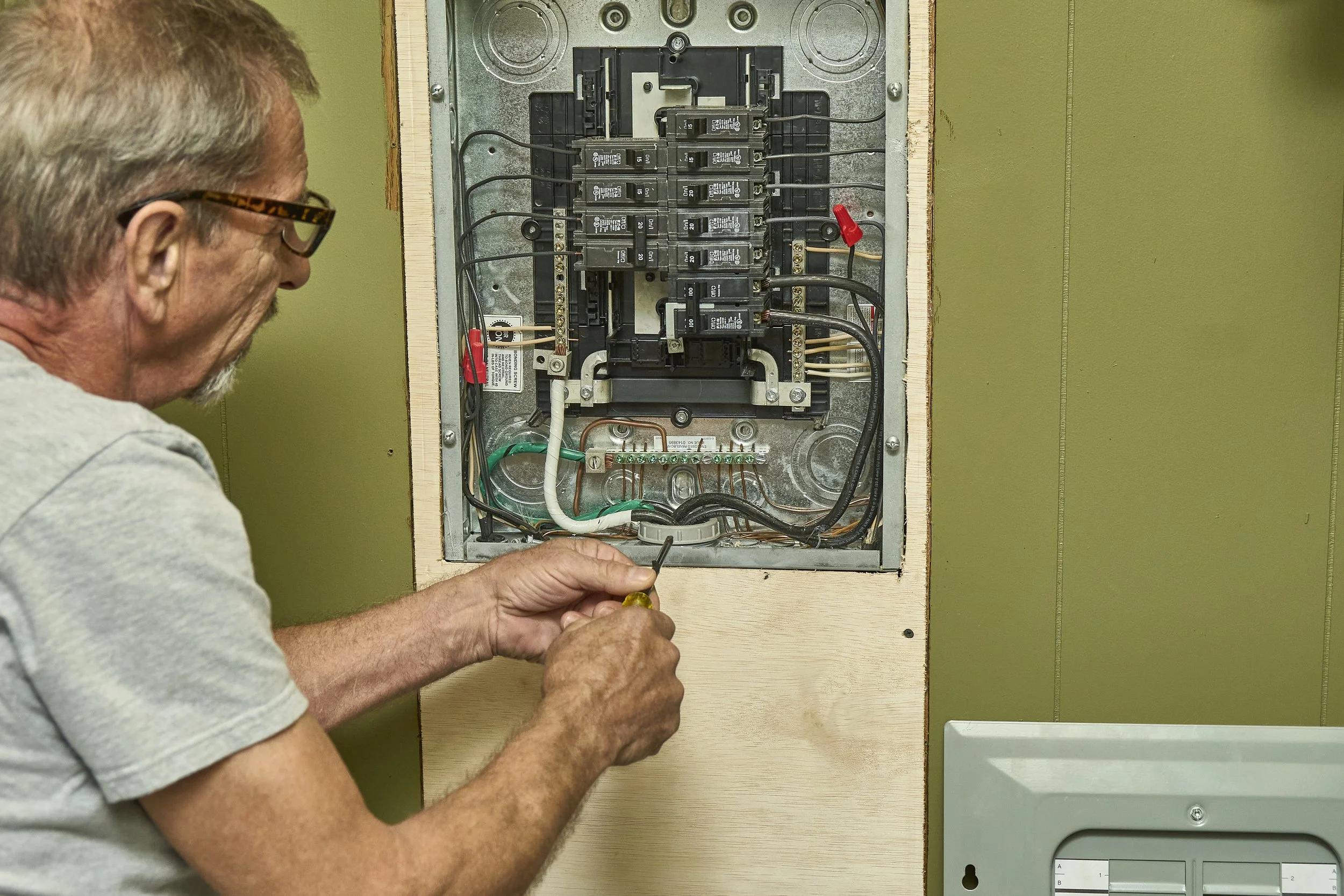 Close-up of an open residential breaker panel with the dead front removed.
