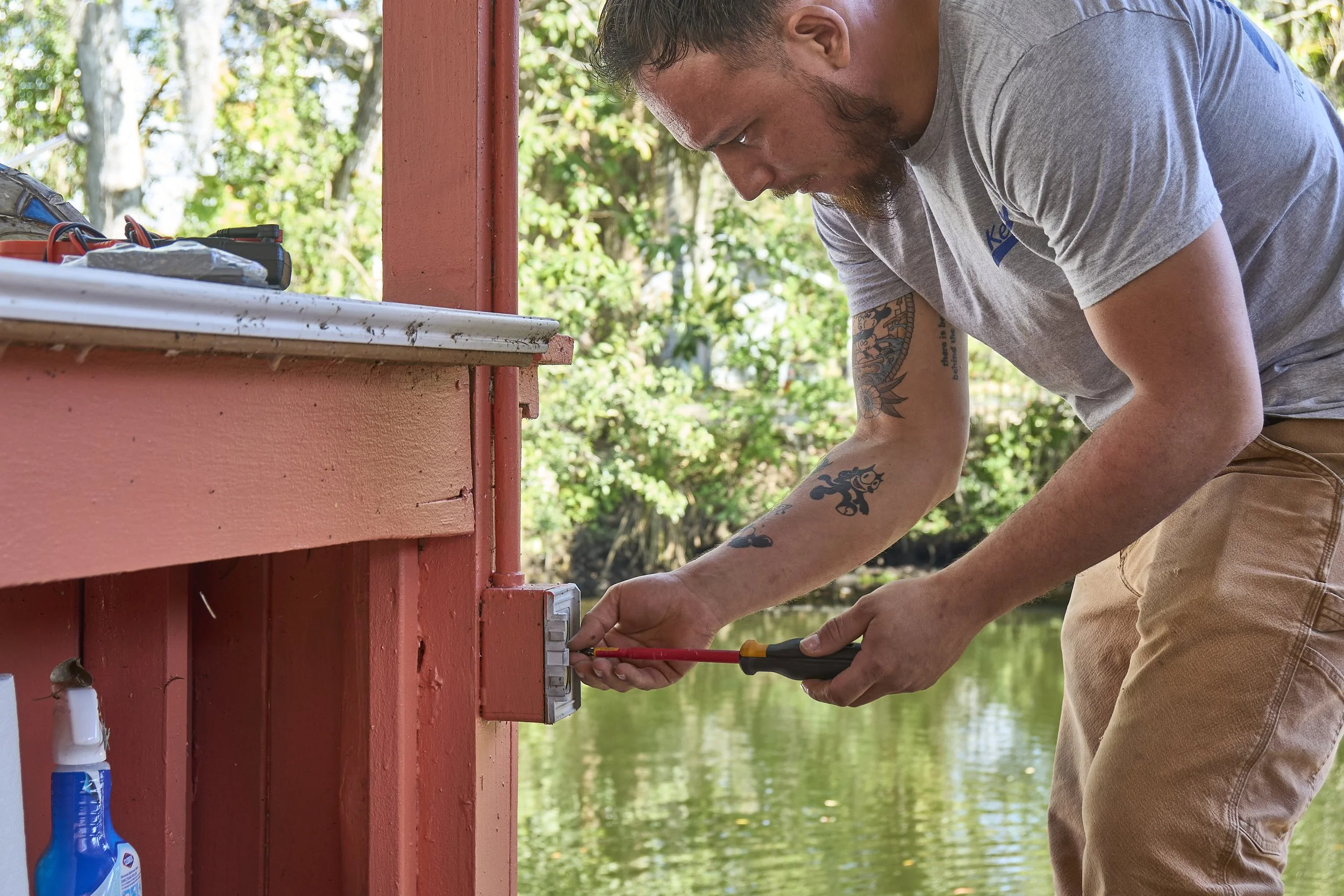 Man working at a dock post/box with pliers
