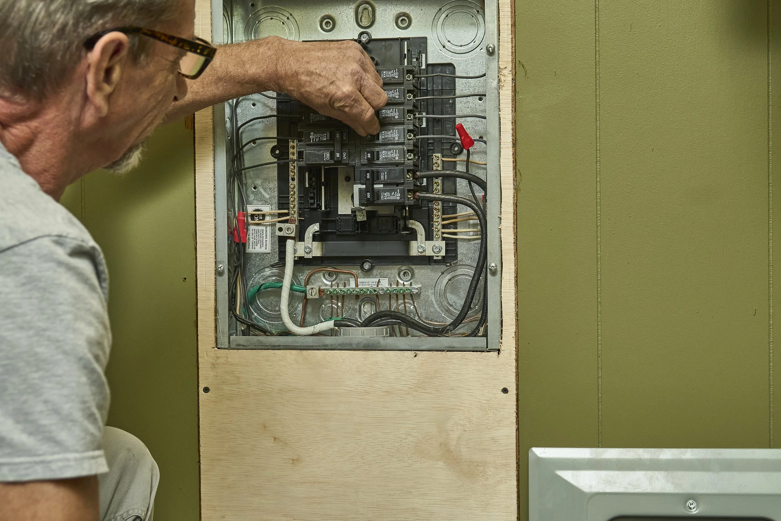 Open residential breaker panel with the dead front removed during a repair visit.
