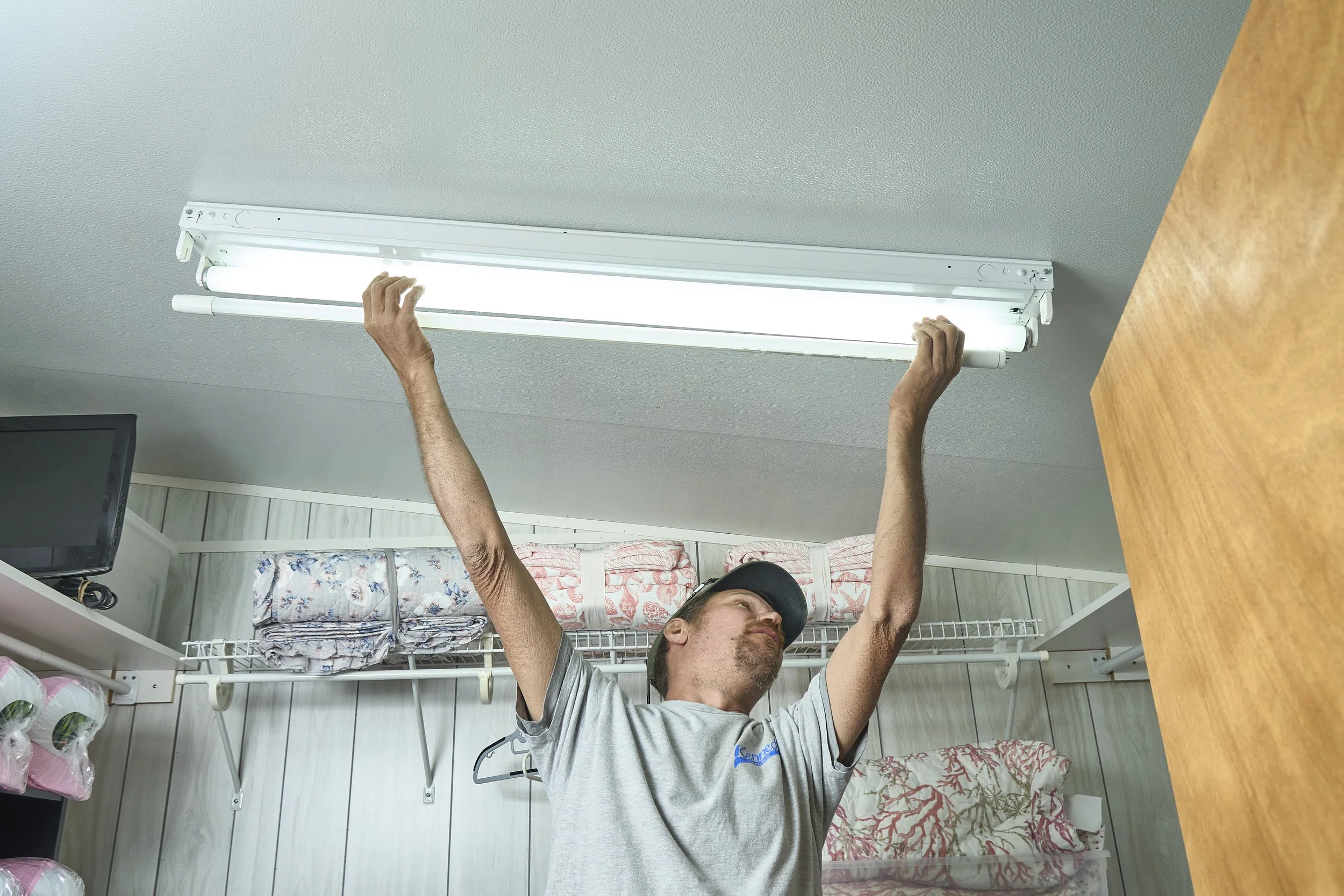 Man installing a linear light fixture on a ceiling