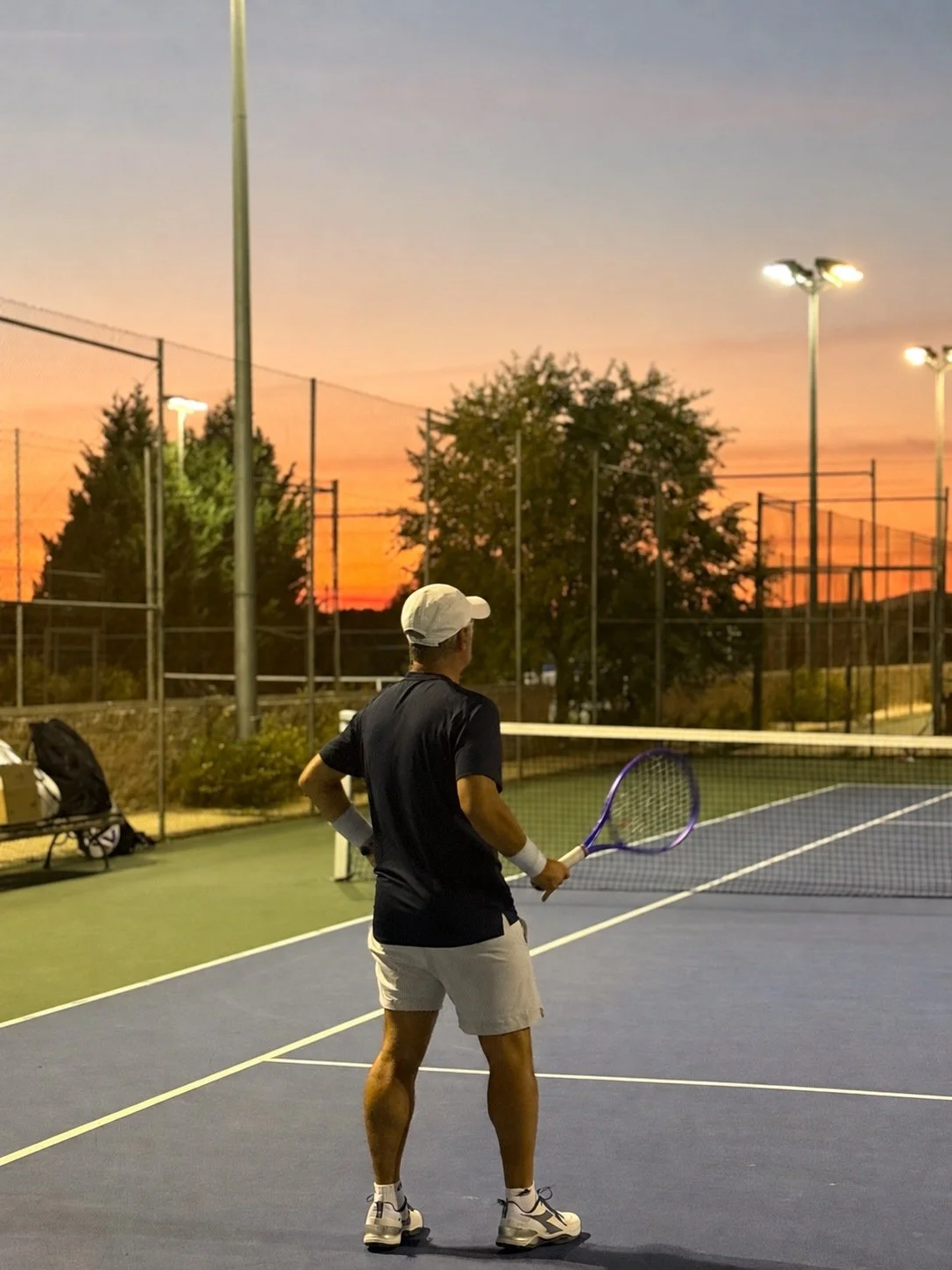 Enzo Bicchieri on a blue tennis court holding his racquet