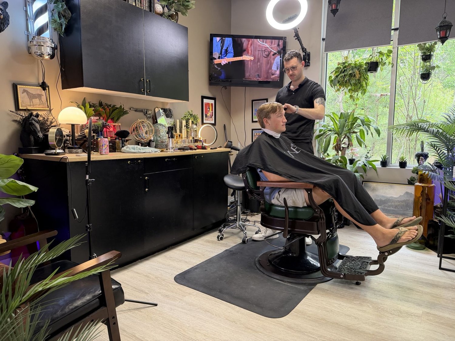 Barber Tyler McDonald cutting a client's hair at Studio XO Salon