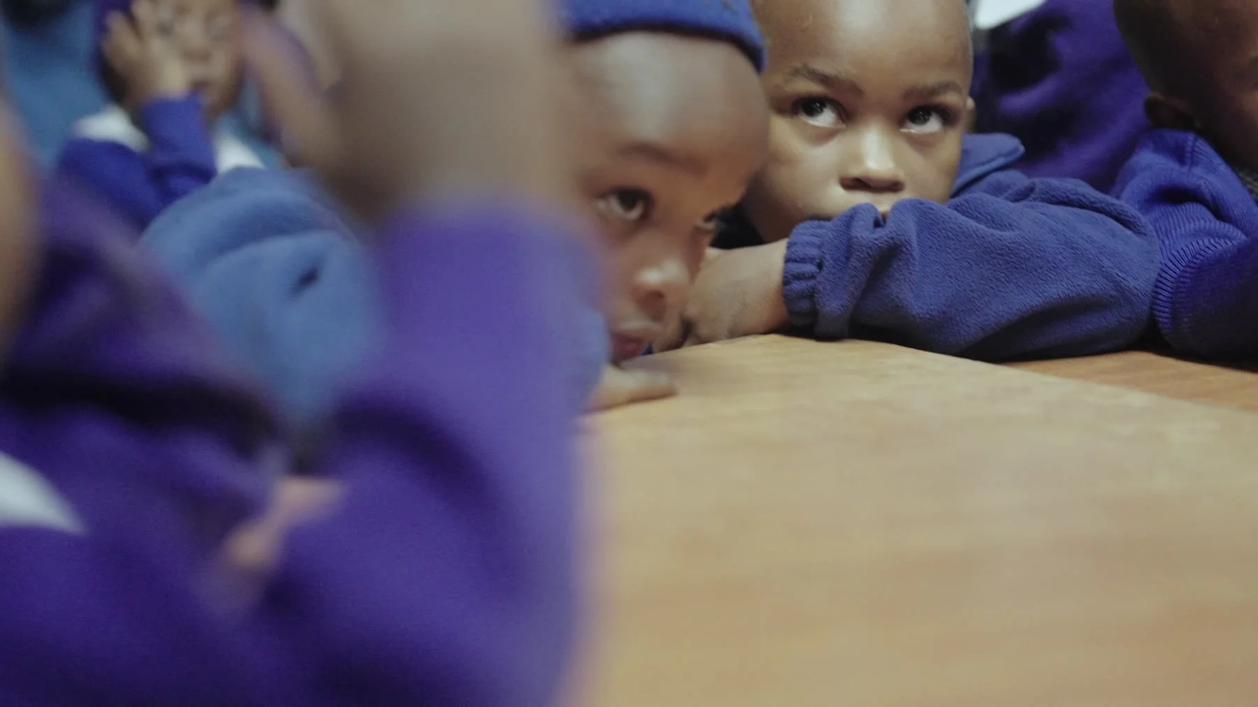 Children together in a Kenyan classroom and at a school water station.