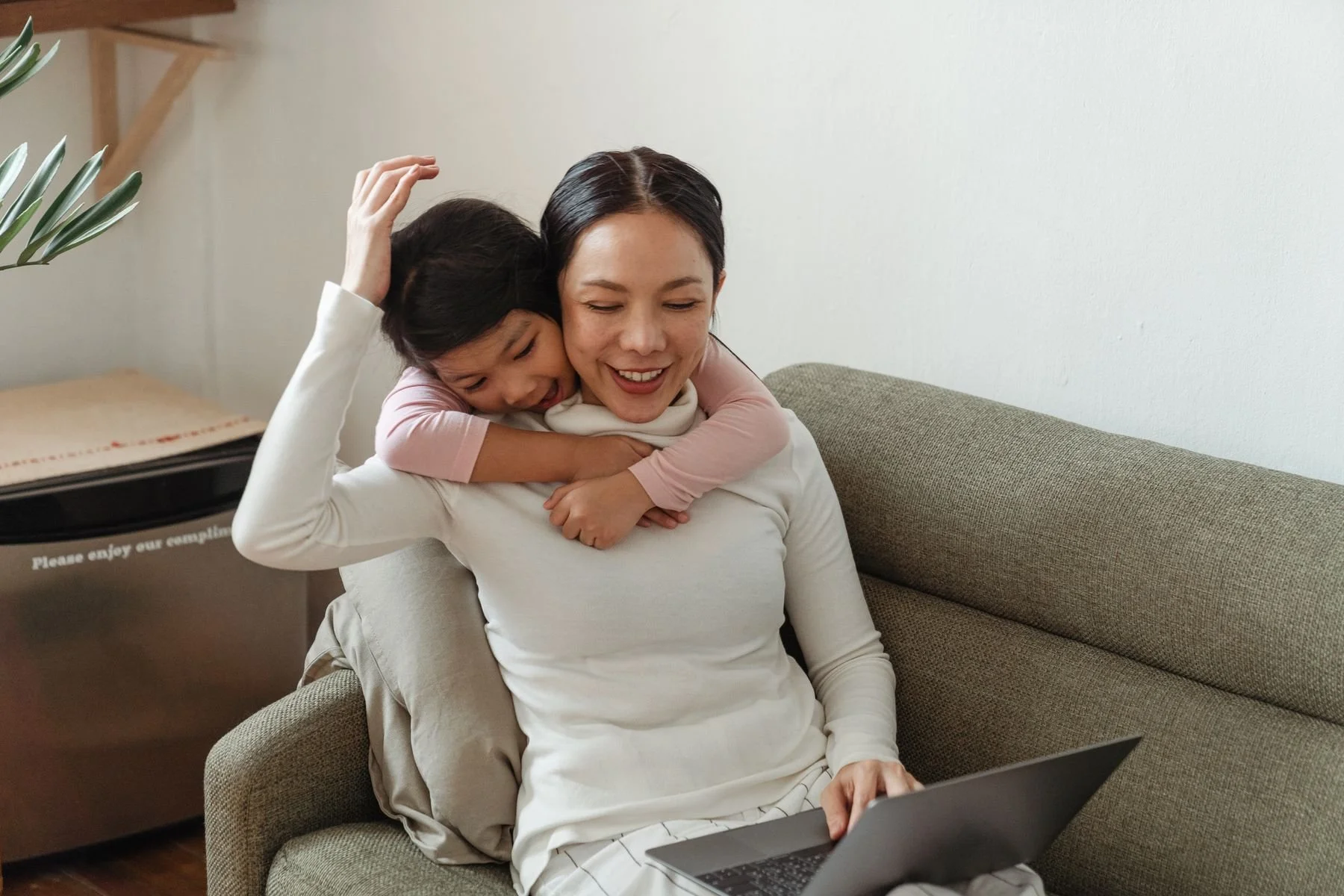 Girl hugging her mother on the couch at home