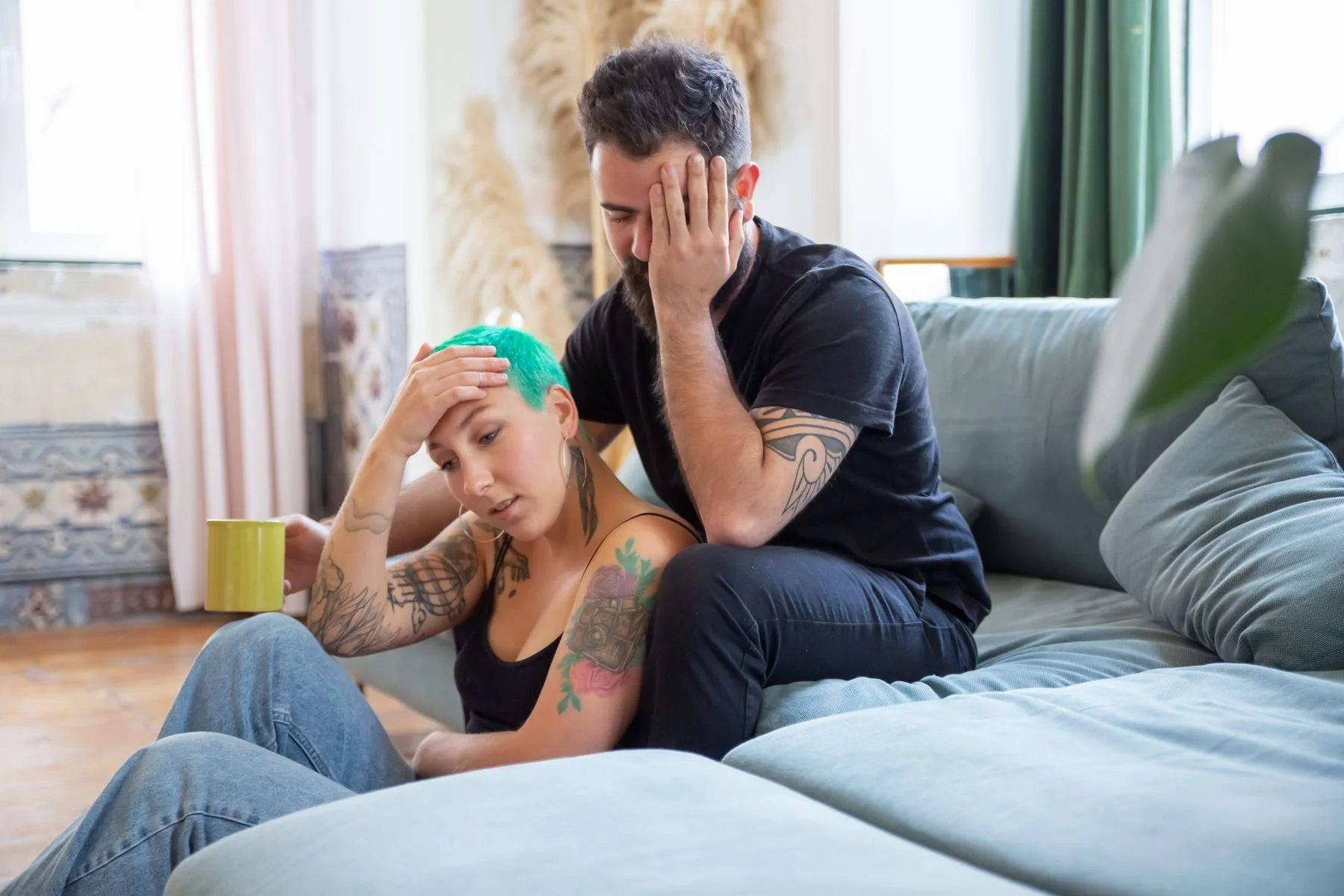 Worried couple sitting together in the living room