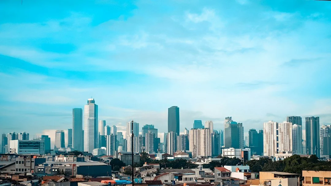 City skyline with commercial buildings beneath a bright blue sky
