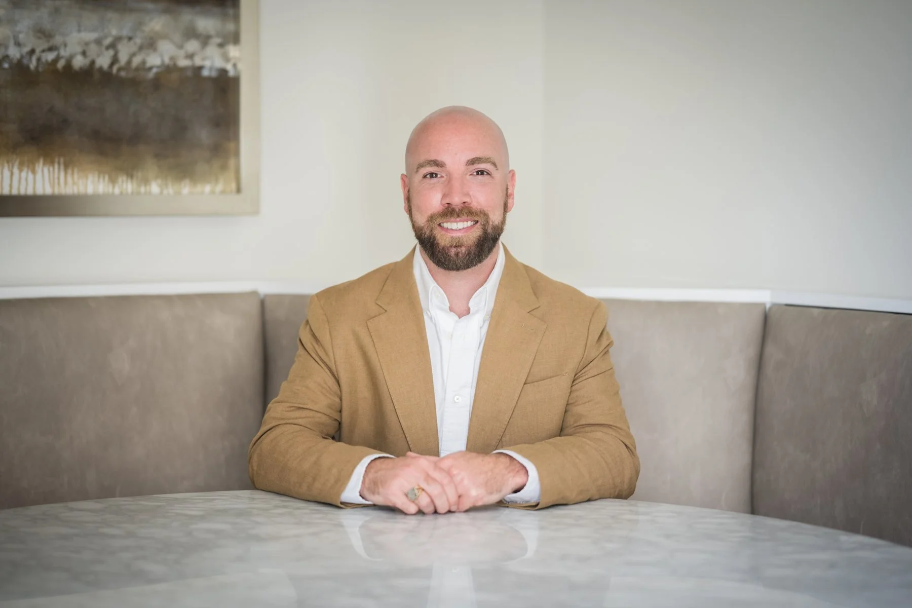 Brent Eckman seated at a marble table, smiling