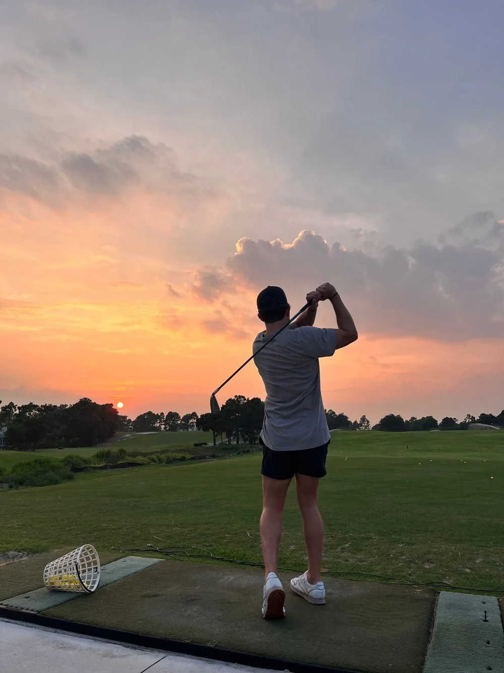 Golfer practicing on a driving range at sunset in Moore County, NC