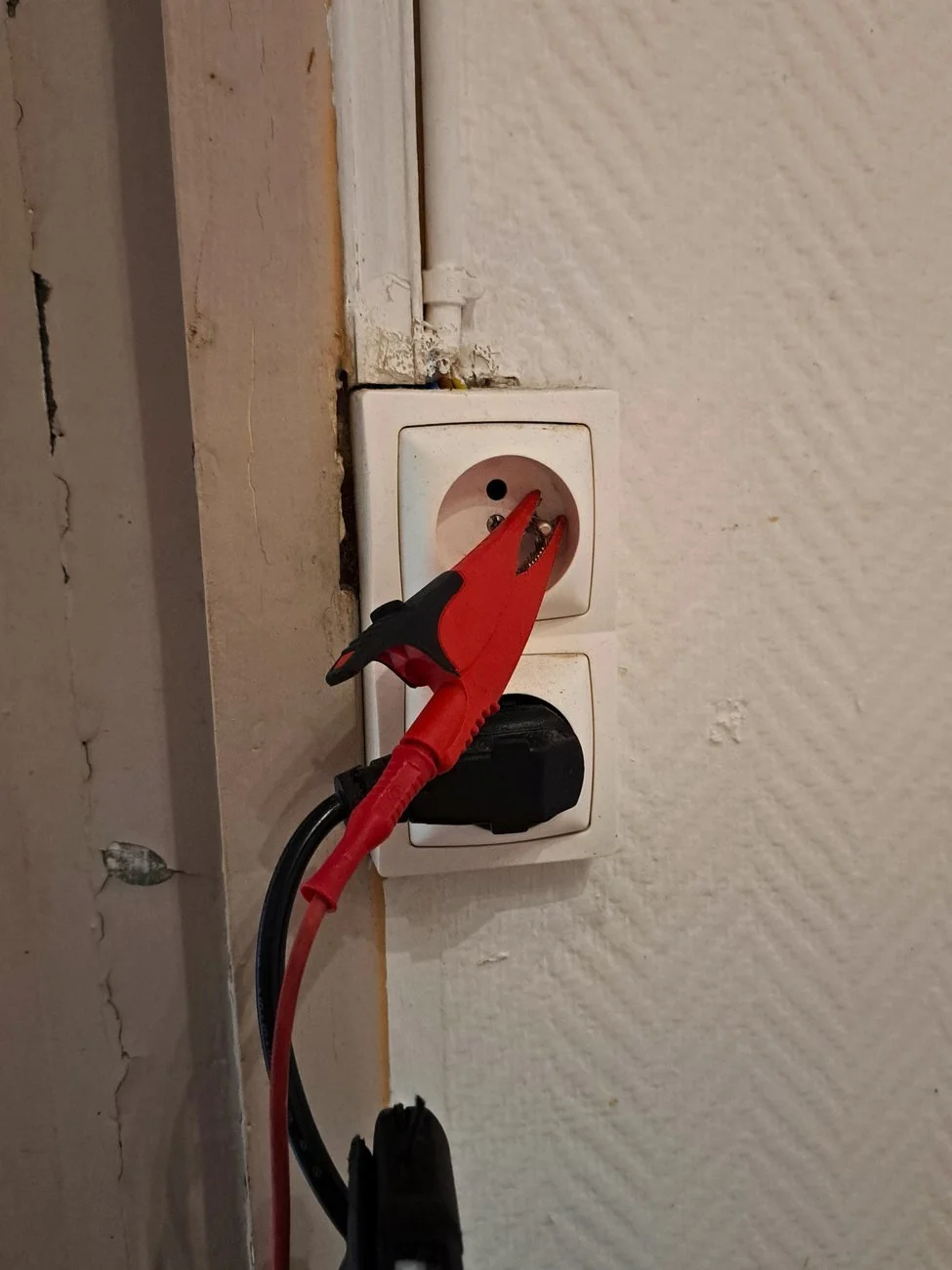 Adaptateur de test branché sur une prise de courant pendant un diagnostic électricité