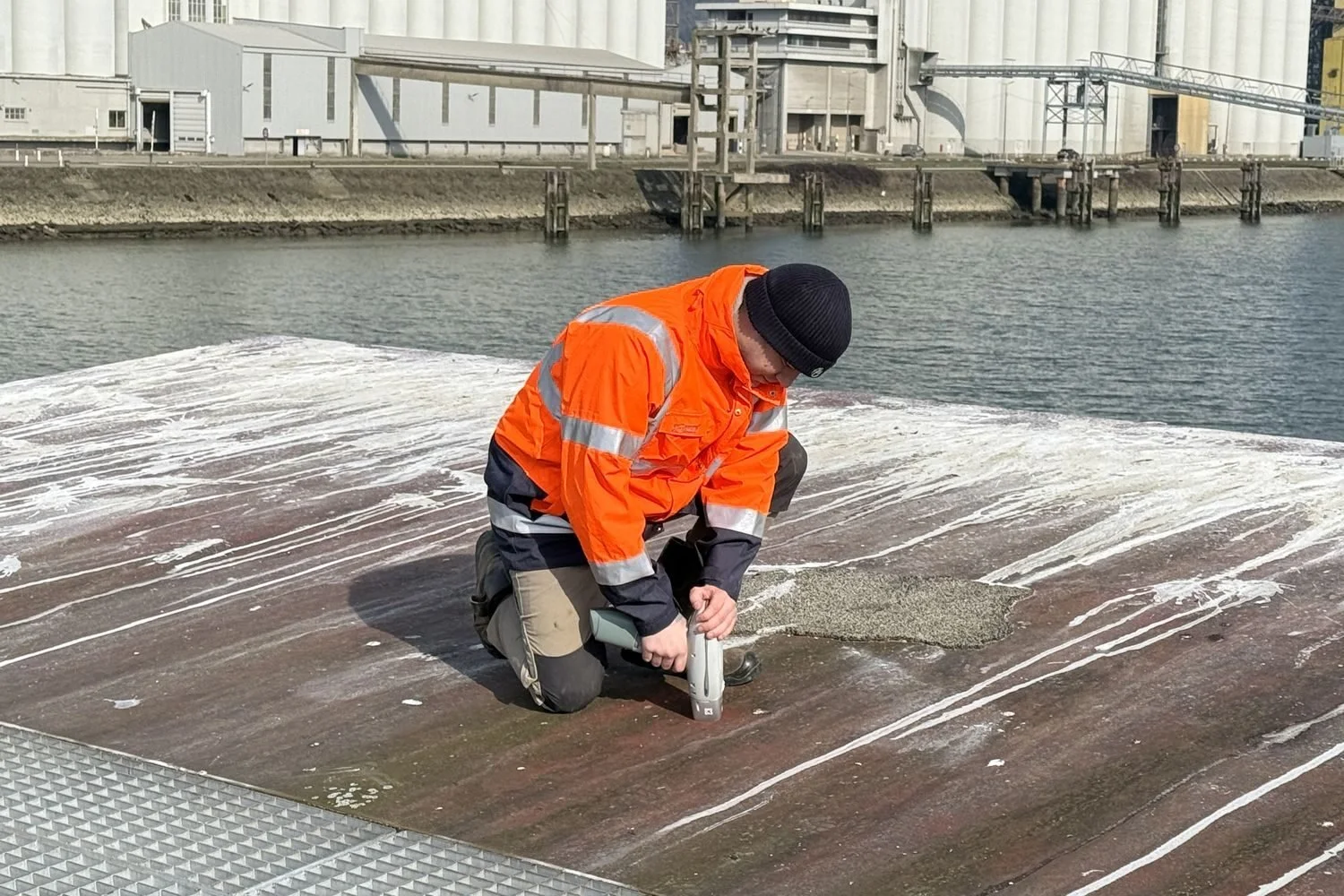 Prélèvement sur un ponton portuaire, en tenue haute visibilité