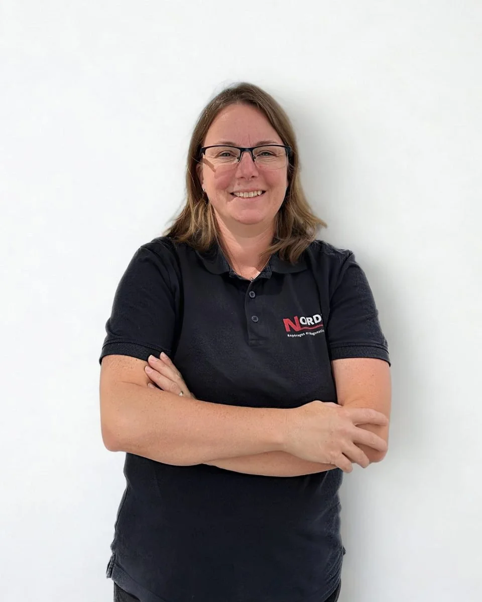 Portrait de Clotilde, auditrice énergétique chez NORDIAG, bras croisés devant un mur blanc