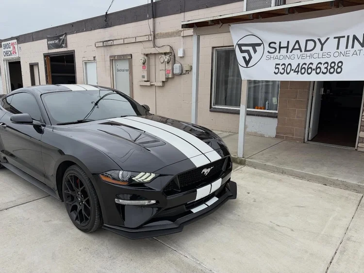 Black Ford Mustang GT with window tint in front of the Shady Tintz banner, Yuba City
