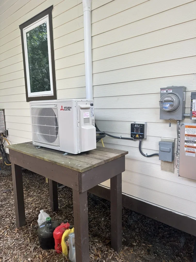 Mitsubishi mini-split outdoor unit on a raised platform