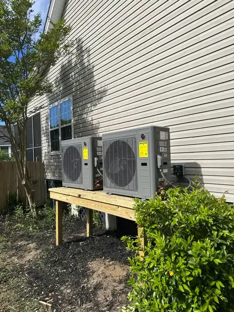 Two outdoor HVAC units on a raised platform