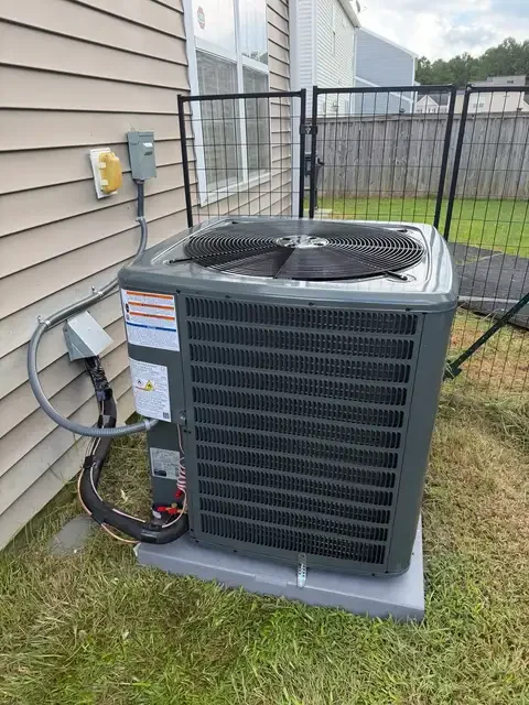 Outdoor HVAC unit on an equipment pad beside a home