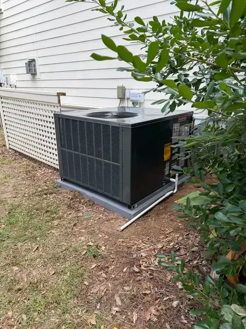 Goodman package unit beside a home