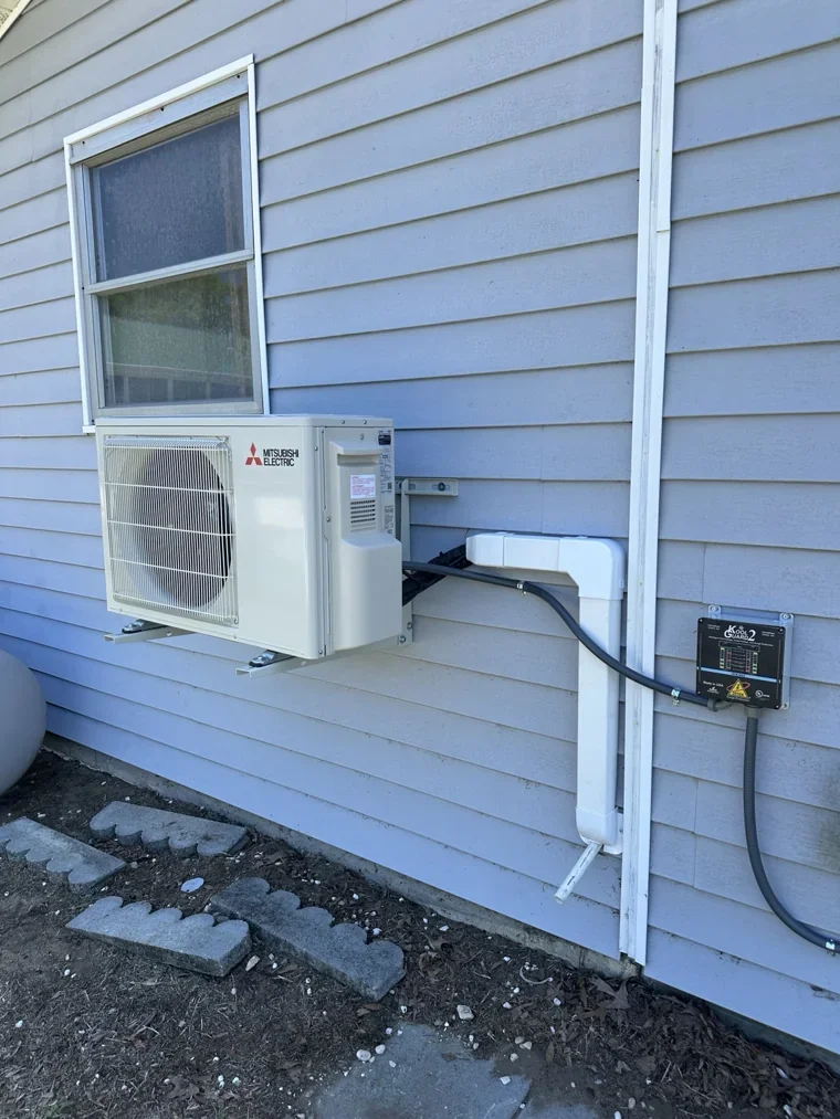Mitsubishi outdoor mini-split unit mounted on wall brackets
