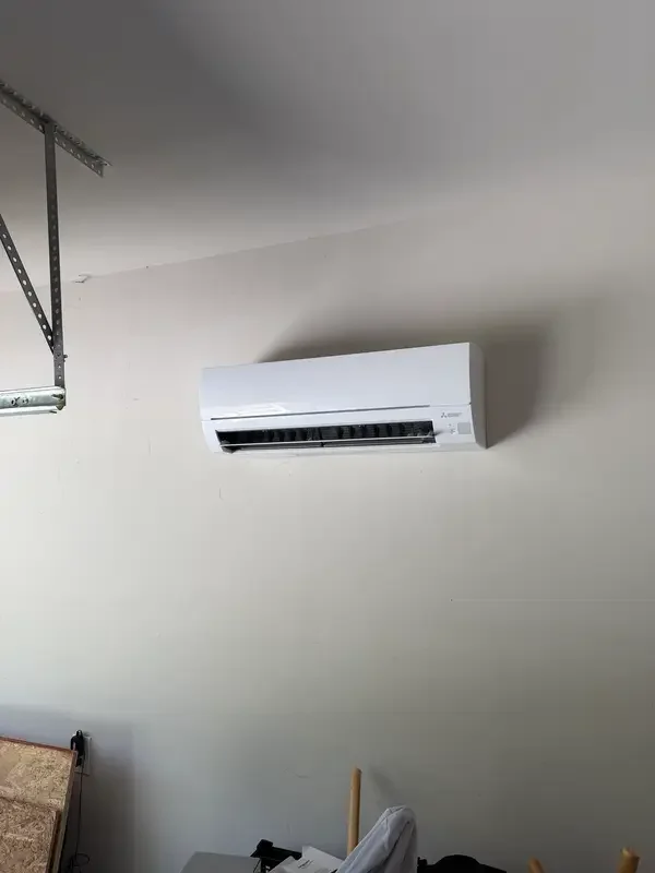 A wall-mounted Mitsubishi mini-split installed in a garage