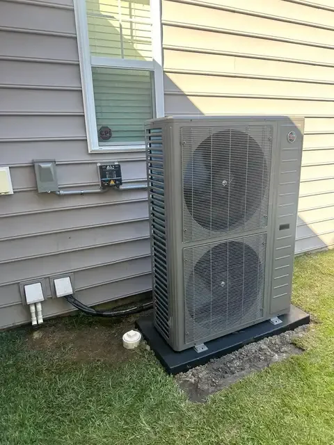 Ruud side-discharge outdoor system beside a home
