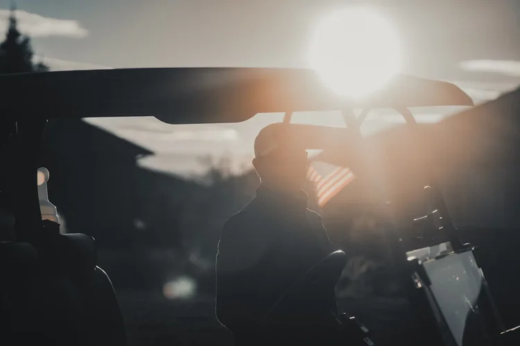 Low winter sunlight falls across clubs in a golf bag.