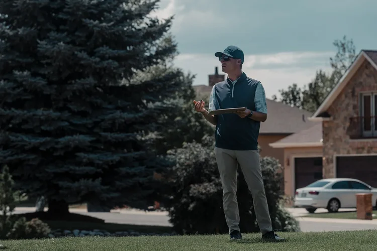 A golfer watches play near the clubhouse.