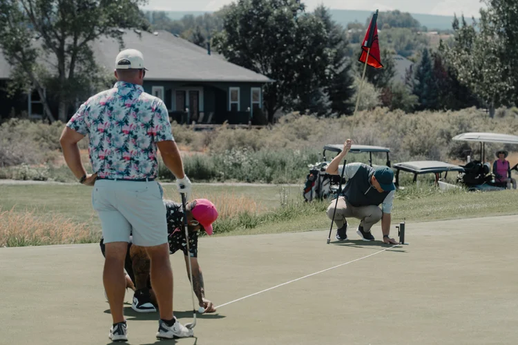Players wait their turn on the putting green.