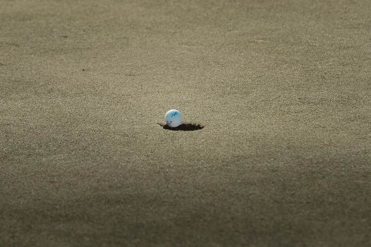 A teed golf ball against the fairway grass.