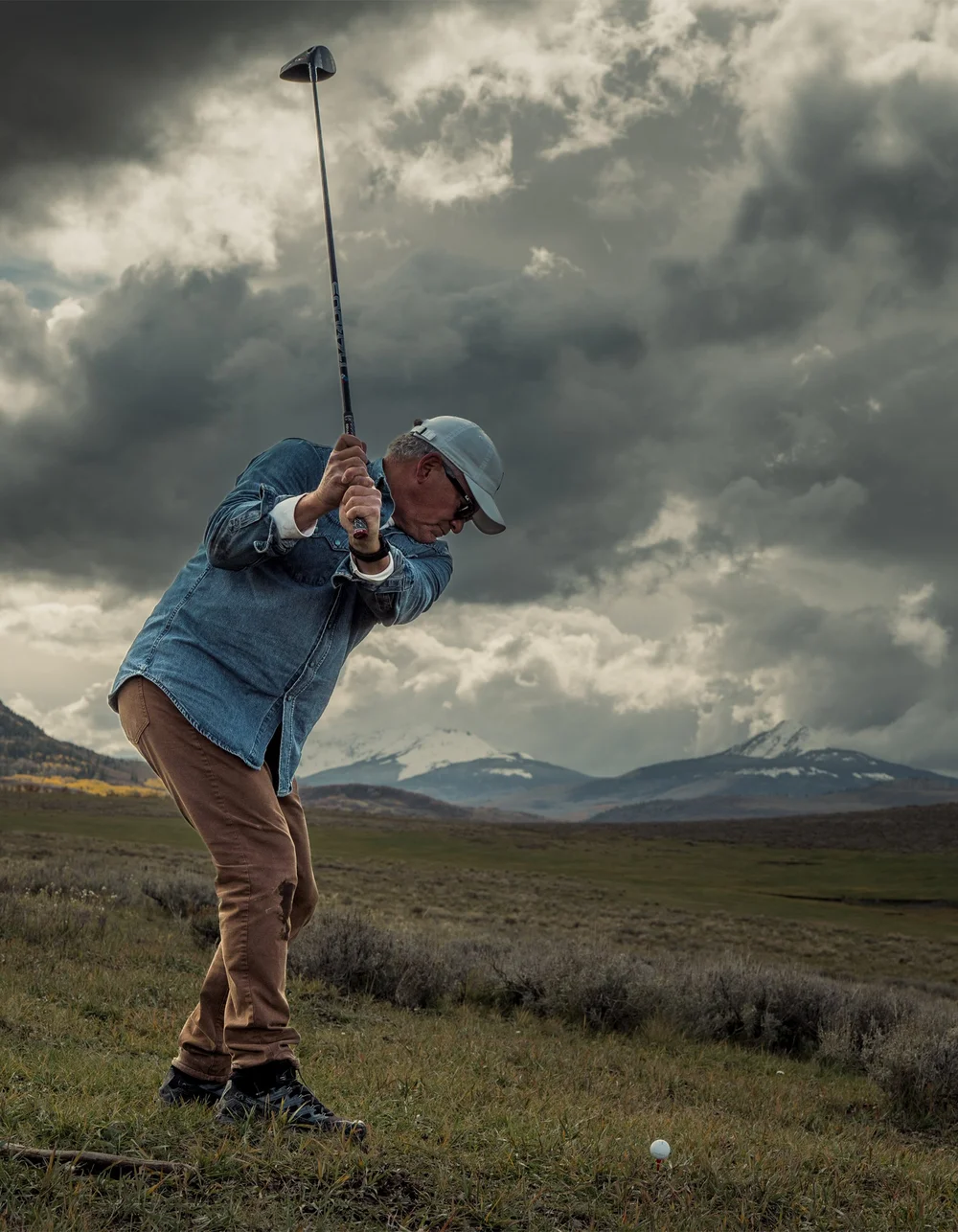A full-length view of the golfer at the top of the backswing.