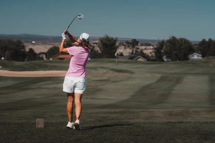 A golfer follows through on a fairway shot.