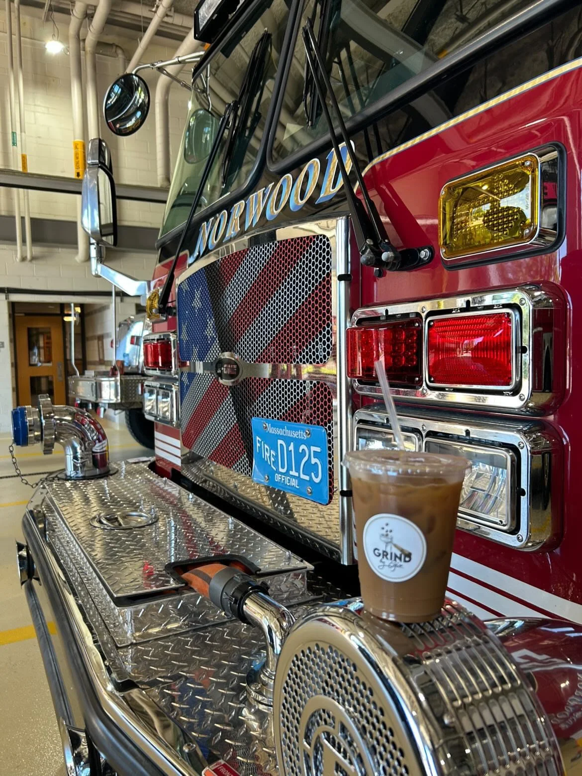 Grind by Gio iced coffee beside a Norwood fire truck