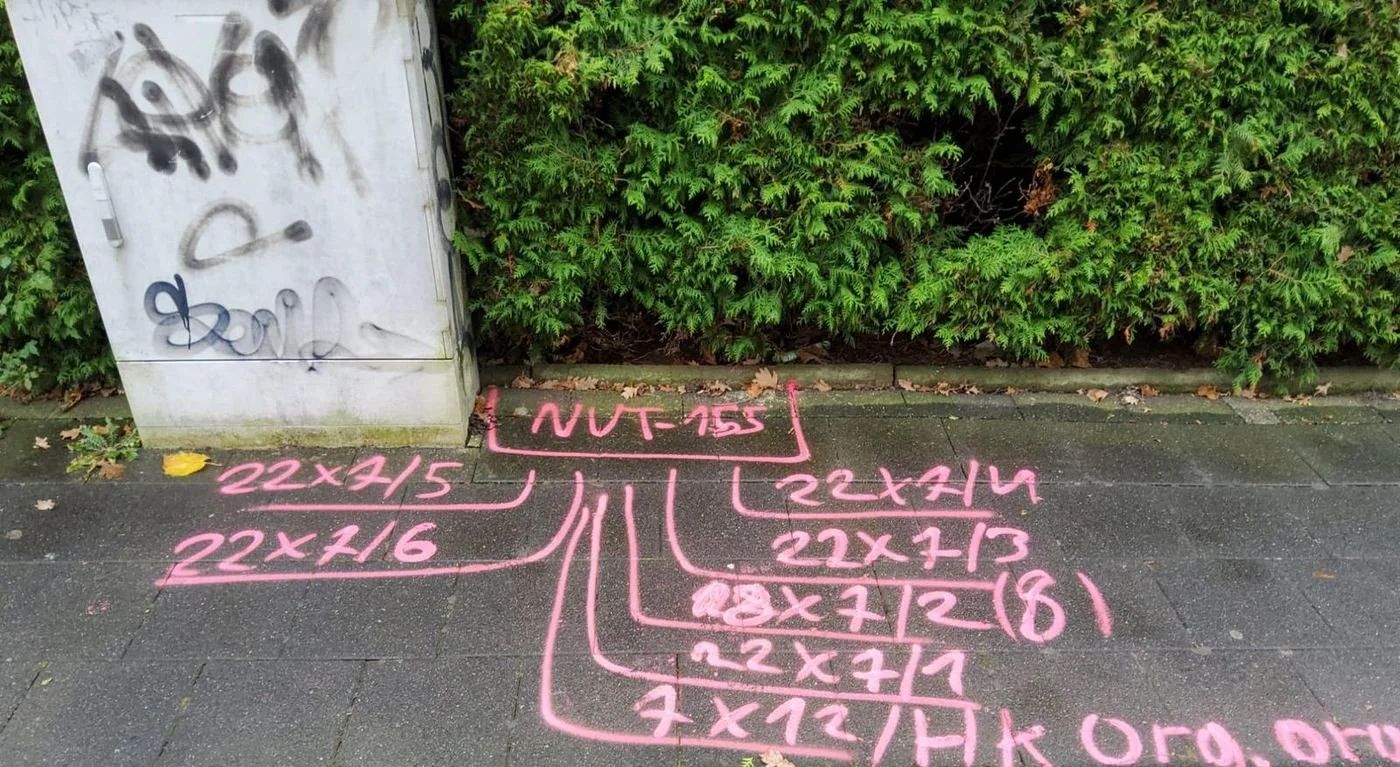Trassenmarkierungen für Glasfaser-Mikrorohre auf einem Gehweg in Paderborn