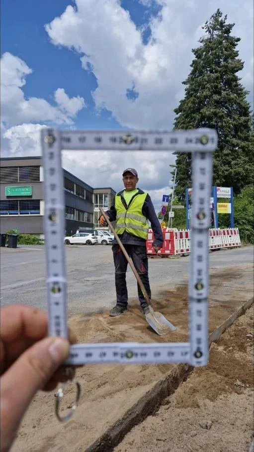 Mitarbeiter der StoneCraft GmbH, eingerahmt von einem Zollstock