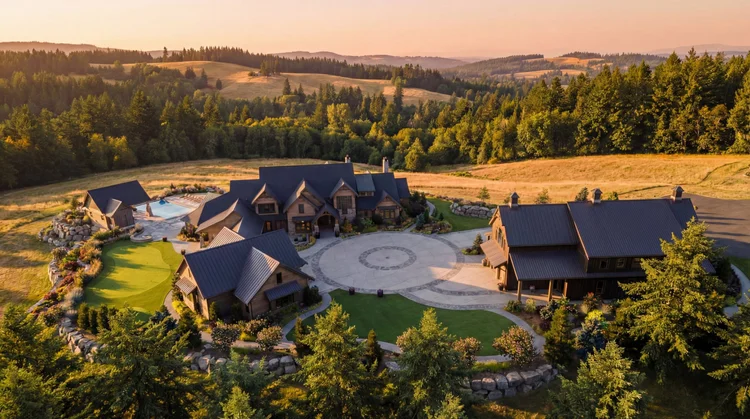 Aerial view of the Solitude estate with its main house, barn, pool and circular motor court at golden hour