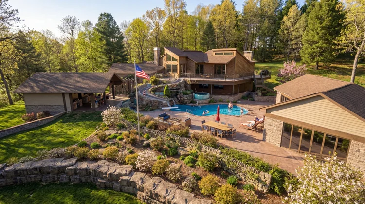 Aerial view of The Grotto backyard with a rock waterfall, slide, spa, pool and terraced gardens