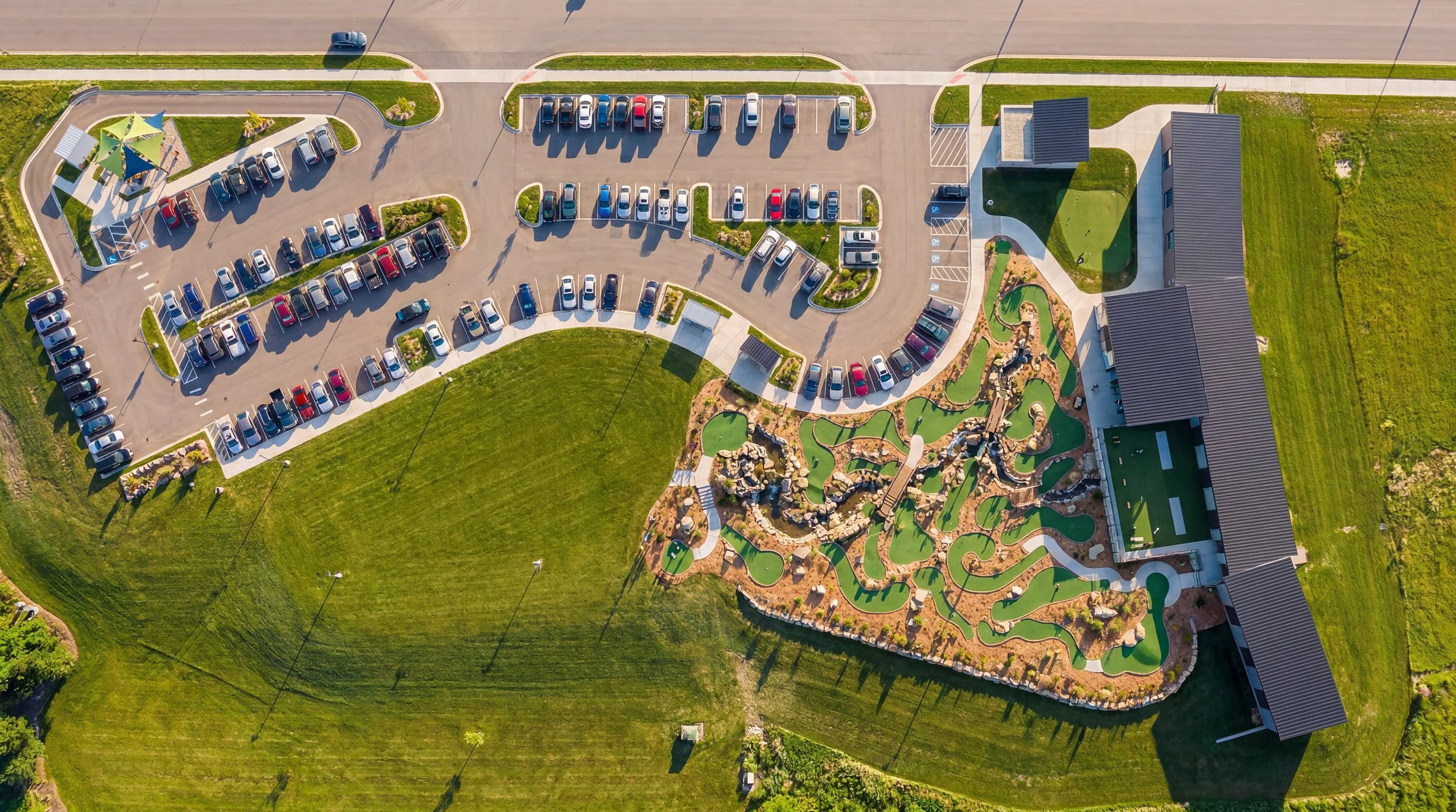 Aerial view of the Gimme Golf site with parking, mini golf course and driving range bays