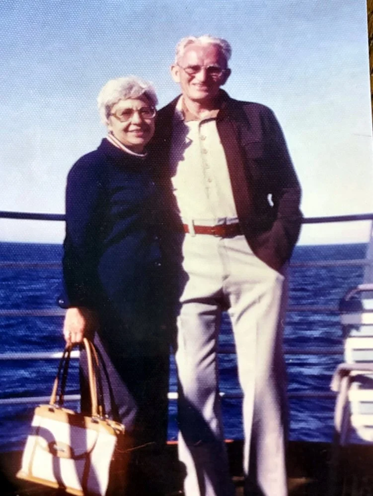 Grandpa Jack and Grandma Lottie standing together on a ship deck with the ocean behind